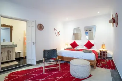 a bedroom with a large bed with red pillows at Riad Bibazia in Marrakech