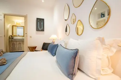 a bedroom with a white bed with pillows and a mirror at Riad Bibazia in Marrakech