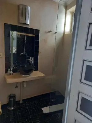 a bathroom with a sink and a glass shower at Riad Les Jardins des Lilas in Marrakech