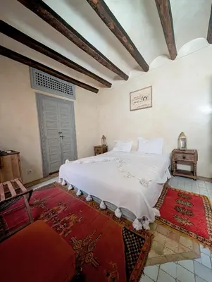 a bedroom with a large white bed in a room at Riad Slitine & Spa in Marrakech