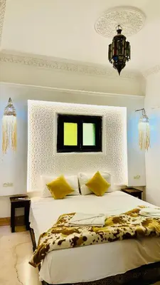 a bedroom with a large white bed with yellow pillows at Riad 46 in Marrakech