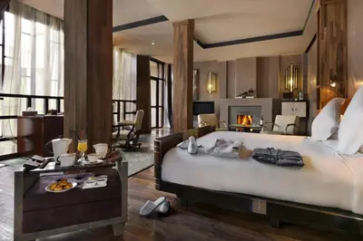 a bedroom with a large bed and a fireplace at Villa Makassar in Marrakech