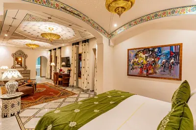 a bedroom with a bed and a living room at La Maison Arabe Hotel, Spa & Cooking Workshops in Marrakech