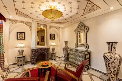 a living room filled with furniture and a mirror at La Maison Arabe Hotel, Spa & Cooking Workshops in Marrakech