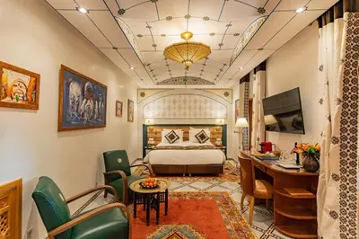 a hotel room with a bed and a desk and chairs at La Maison Arabe Hotel, Spa & Cooking Workshops in Marrakech