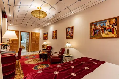 a bedroom with a bed and a living room at La Maison Arabe Hotel, Spa & Cooking Workshops in Marrakech