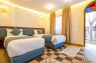 a hotel room with two beds and a window at Riad Hamdane Rooftop & SPA in Marrakech