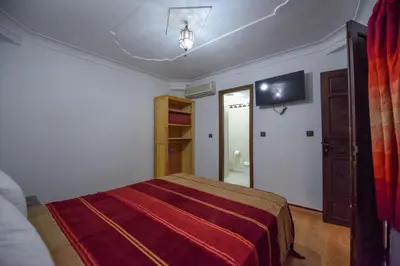 a bedroom with a bed and a tv on the wall at Riad Assia in Marrakech