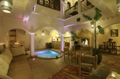 a living room with a swimming pool in a building at Riad L'Emir in Marrakech