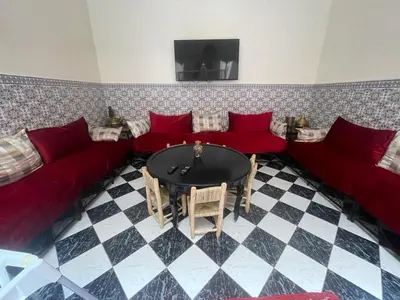 a living room with red couches and a table at Ryad Nayla in Marrakech