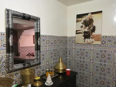 a bathroom with a mirror on a tiled wall at Ryad Nayla in Marrakech