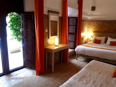 a hotel room with two beds and a window at Riad Amira in Marrakech