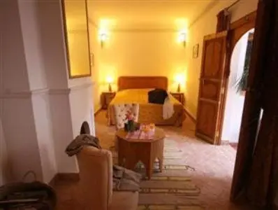 a living room with a bed and a table at Riad Chameau FDC Hôtel SPA in Marrakech