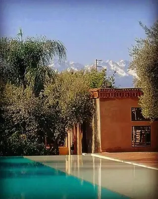 a house with a swimming pool next to a building at Manzil La Tortue in Douar Caïd Layadi