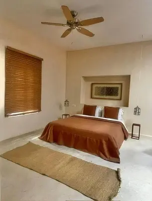 a bedroom with a bed with a ceiling fan at Manzil La Tortue in Douar Caïd Layadi