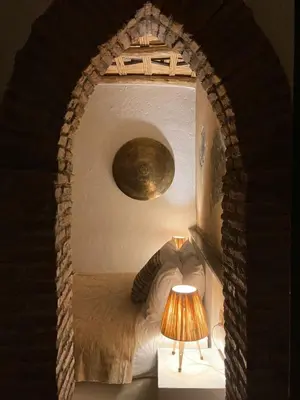 a bedroom with a bed and a table with a lamp at Manzil La Tortue in Douar Caïd Layadi