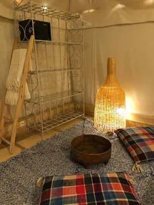 a room with a lamp and a bed with a blanket at Manzil La Tortue in Douar Caïd Layadi