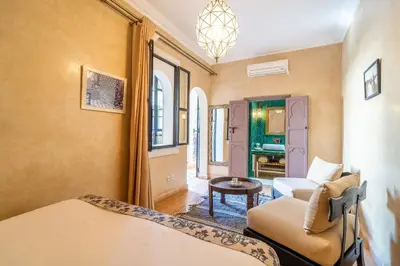 a room with a bed and a couch and a table at Riad Beldi in Marrakech