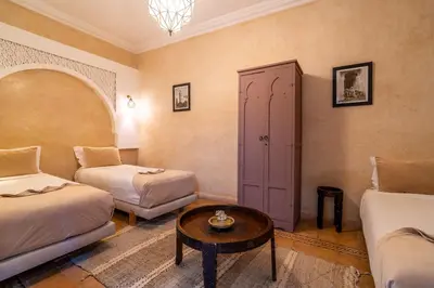 a room with two beds and a coffee table at Riad Beldi in Marrakech