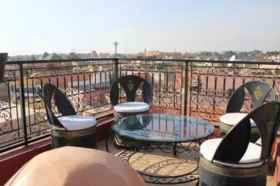 a balcony with chairs and a table on a balcony at Riad Mboja Chez Ali Baba in Marrakech
