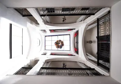a white room with a spiral staircase with a window at Riad Mboja Chez Ali Baba in Marrakech