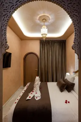 a hotel room with a bed with slippers on it at Riad Mabrouk in Marrakech