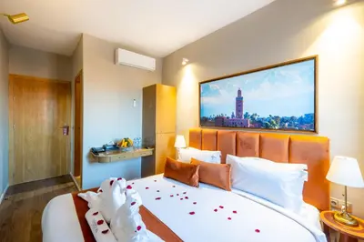 a bedroom with a large bed with a large picture on the wall at Riad Mabrouk in Marrakech