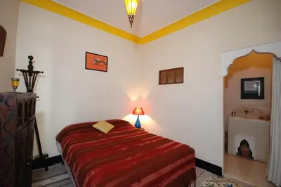 a bedroom with a bed in a room with a fireplace at Riad El Sagaya in Marrakech