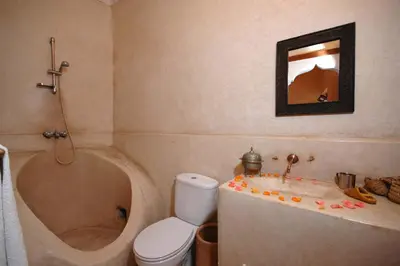 a bathroom with a tub and a toilet and a sink at Riad El Sagaya in Marrakech