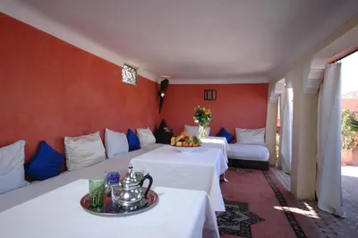 a hotel room with two beds and two tables at Riad El Sagaya in Marrakech