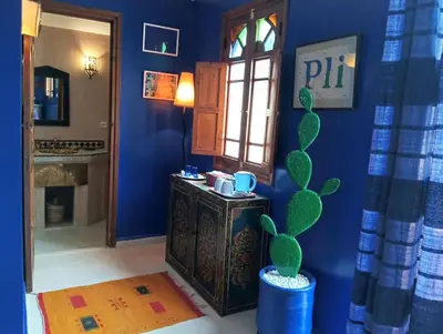 a room with a blue wall with a cactus at Dar Taliwint in Marrakech