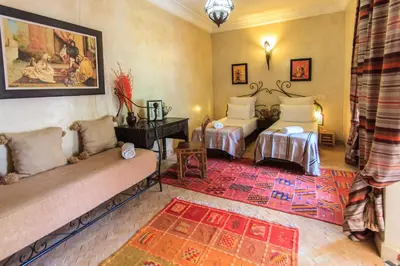 a living room with two beds and a rug at Riad Nabila in Marrakech