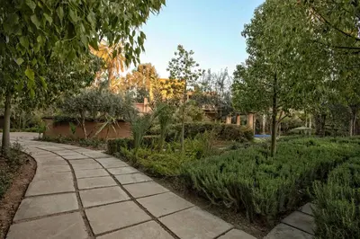 a walkway in a garden with trees and bushes at Villa de Luxe Domaine des Kasbahs in Marrakech