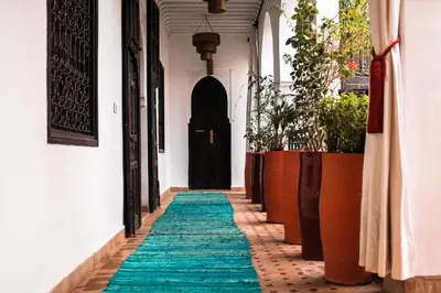 a hallway with a green carpet and a black door at Riad Pachavana in Marrakech