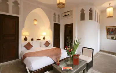 a bedroom with a bed and a desk and a bed sidx sidx sidx at Riad Pachavana in Marrakech