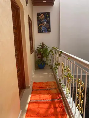 a stairway with an orange rug on the floor and a plant at Dar Dikrayat in Marrakech