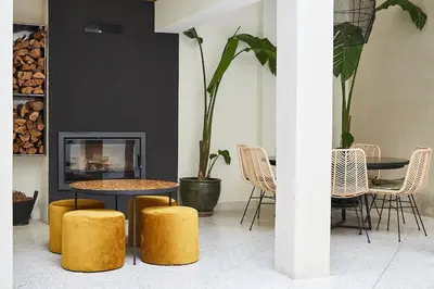 a room with a table and chairs and a fireplace at Numa Marrakech in Marrakech