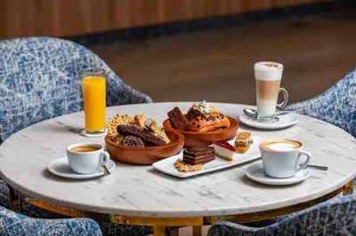 a table with a tray of food and two cups of coffee at Pickalbatros Hôtel Du Golf - Adults Friendly 16 Years Plus- All-Inclusive in Marrakech