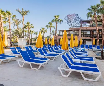 a group of lounge chairs and umbrellas at a resort at Pickalbatros Hôtel Du Golf - Adults Friendly 16 Years Plus- All-Inclusive in Marrakech