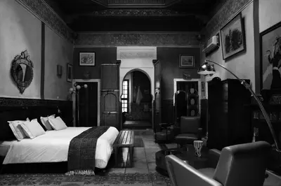 a bedroom with a bed and a couch and a chair at Riad Malika in Marrakech