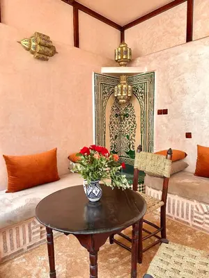 a living room with a table and a couch at Riad Tasneem in Marrakech