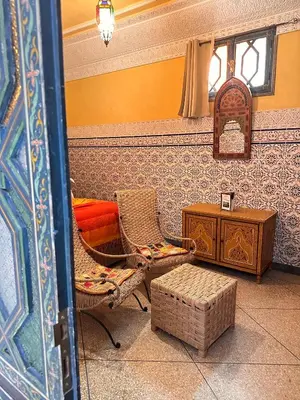 a living room with a chair and a table at Riad Tasneem in Marrakech