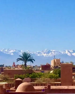 a view of a city with snow capped mountains in the background at Riad Safar in Marrakech
