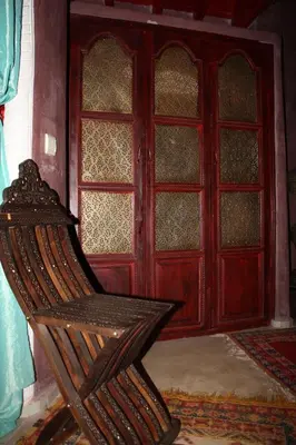a wooden chair sitting in front of a door at Riad Lorsya in Marrakech