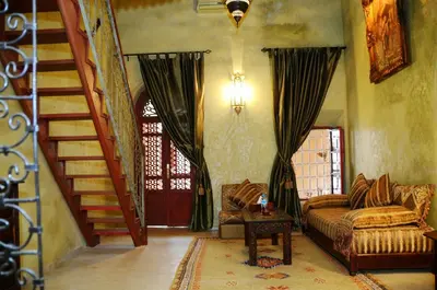 a living room with a couch and a staircase at Riad Lorsya in Marrakech