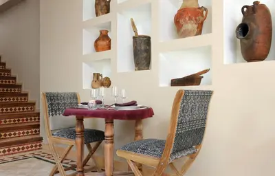 a dining room with a table and chairs and vases at La Villa Nomade in Marrakech