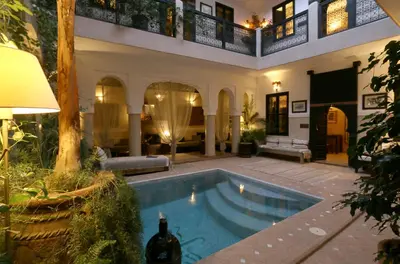 a house with a swimming pool in a yard at Riad Anjar in Marrakech