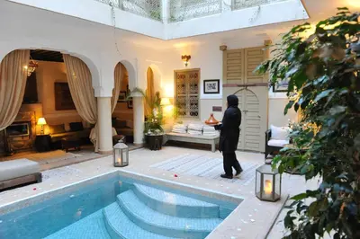 a man standing in front of a swimming pool at Riad Anjar in Marrakech