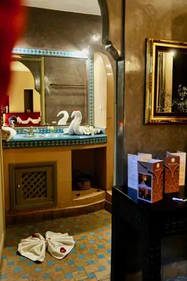 a bathroom with a sink and two swans on the floor at Riad Anjar in Marrakech