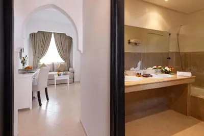a bathroom with a sink and a vanity with a mirror at Marrakech Ryads Parc All inclusive in Marrakech